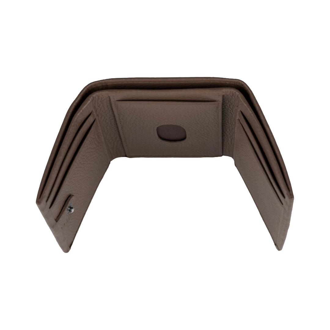 A brown textured faux-leather interior panel or trim piece with multiple card slots and a central oval cutout, shown on a plain white background.
