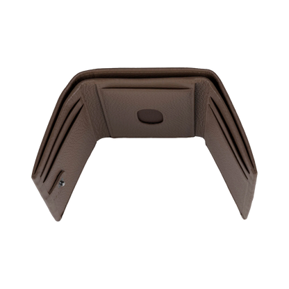 A brown textured faux-leather interior panel or trim piece with multiple card slots and a central oval cutout, shown on a plain white background.