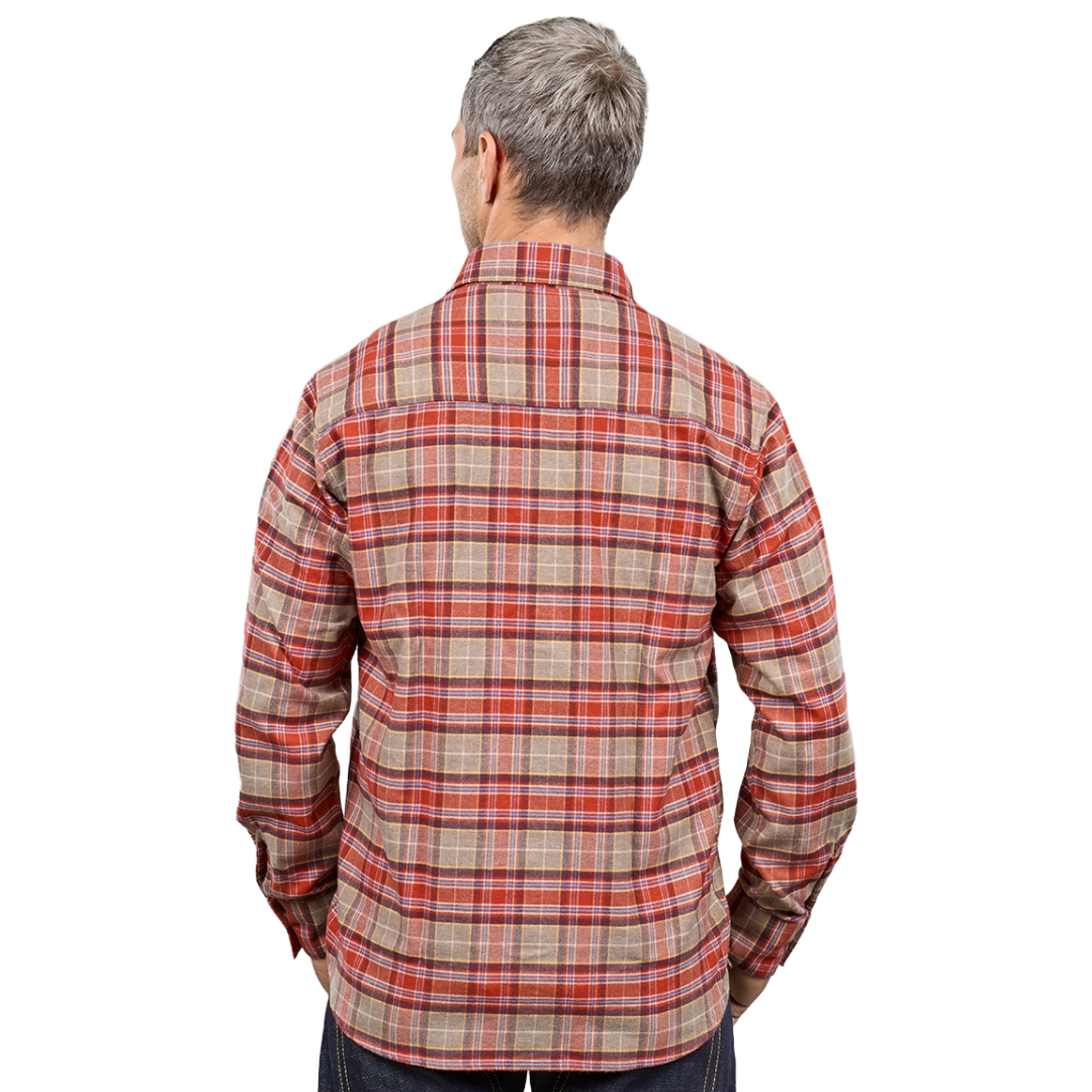 A man viewed from the back wearing a long-sleeve plaid button-up shirt in beige, red, and orange tones, paired with dark pants, against a plain white background.
