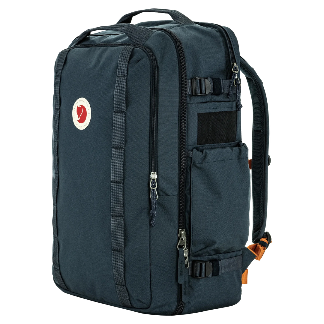 A dark navy blue Fjälör backpack with multiple zippered compartments, side compression straps, and a small red and white logo on the front, shown against a plain white background.