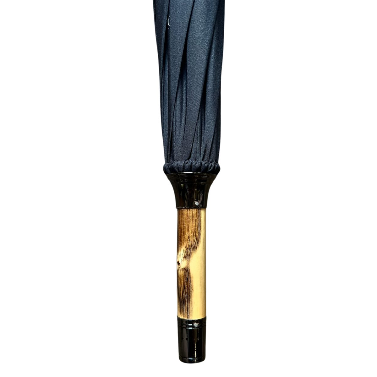 A close-up of an umbrella handle and canopy showing a dark navy blue fabric top and a polished light brown wooden handle with black plastic end caps, isolated on a white background.