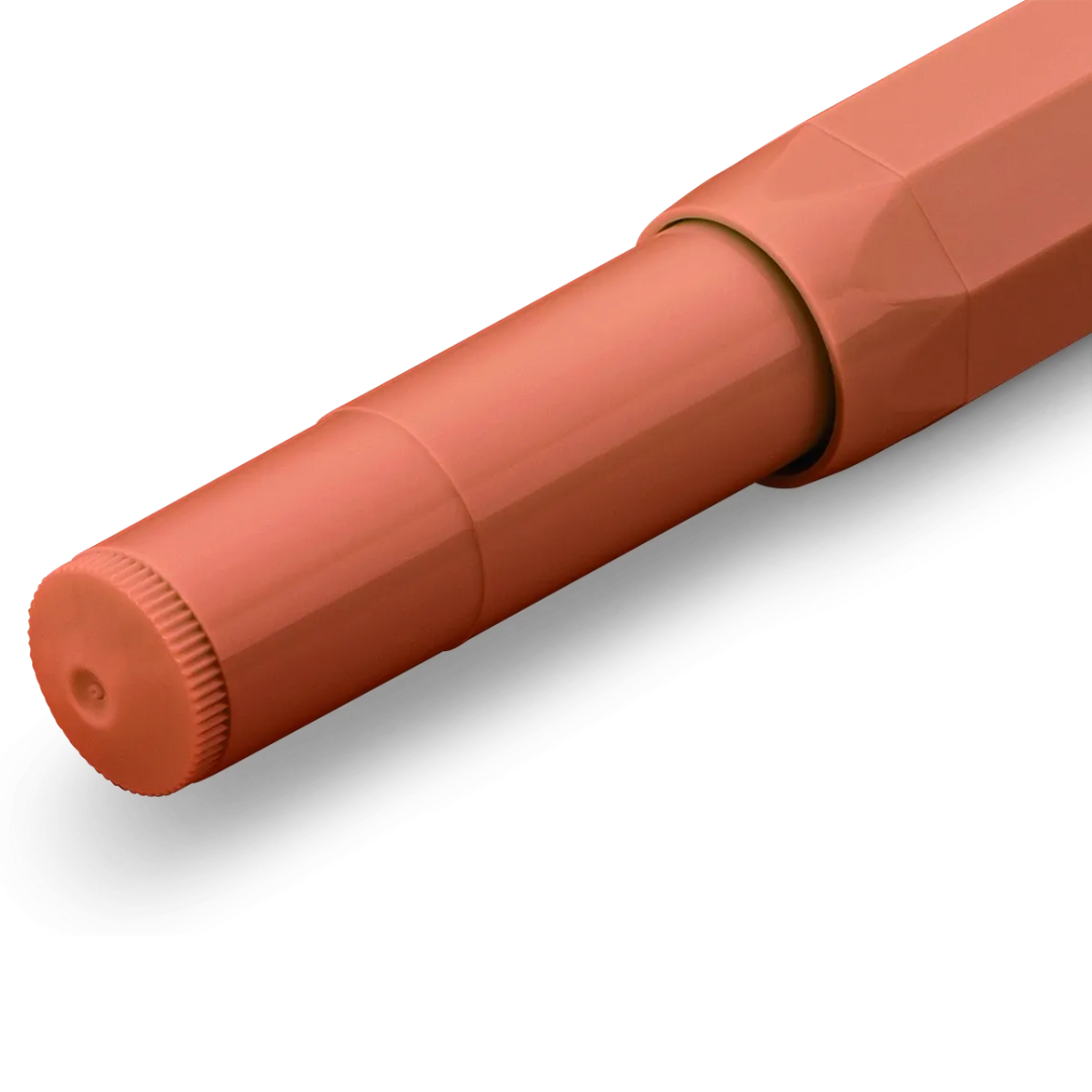 A close-up of a terracotta orange pen cap with a ribbed textured edge, shown on a clean white background.