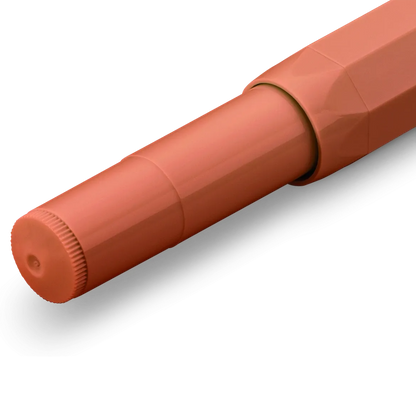 A close-up of a terracotta orange pen cap with a ribbed textured edge, shown on a clean white background.