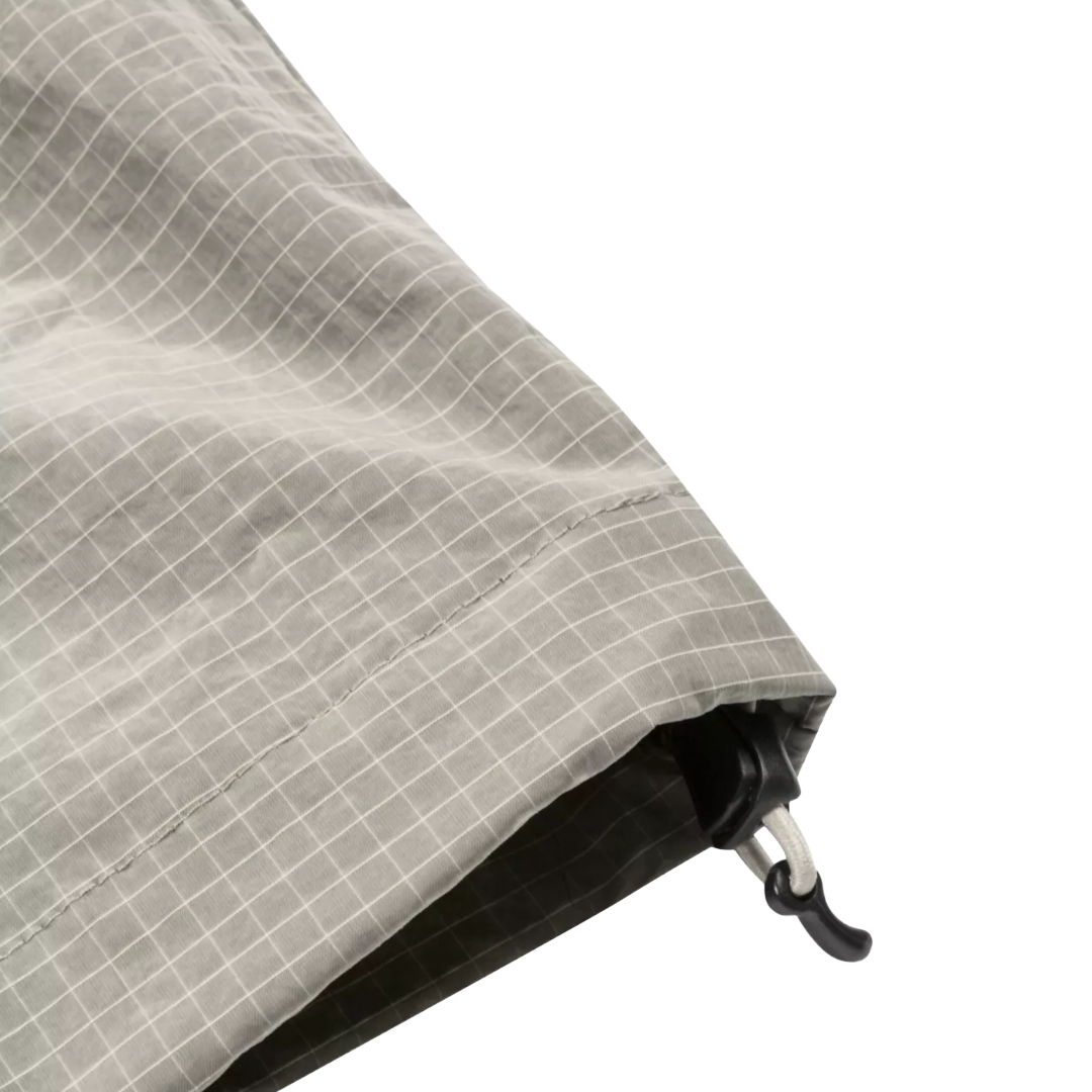 Close-up of a gray and white grid-patterned fabric with a black plastic hook-and-loop closure, shown on a plain white background.