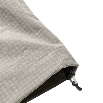Close-up of a gray and white grid-patterned fabric with a black plastic hook-and-loop closure, shown on a plain white background.