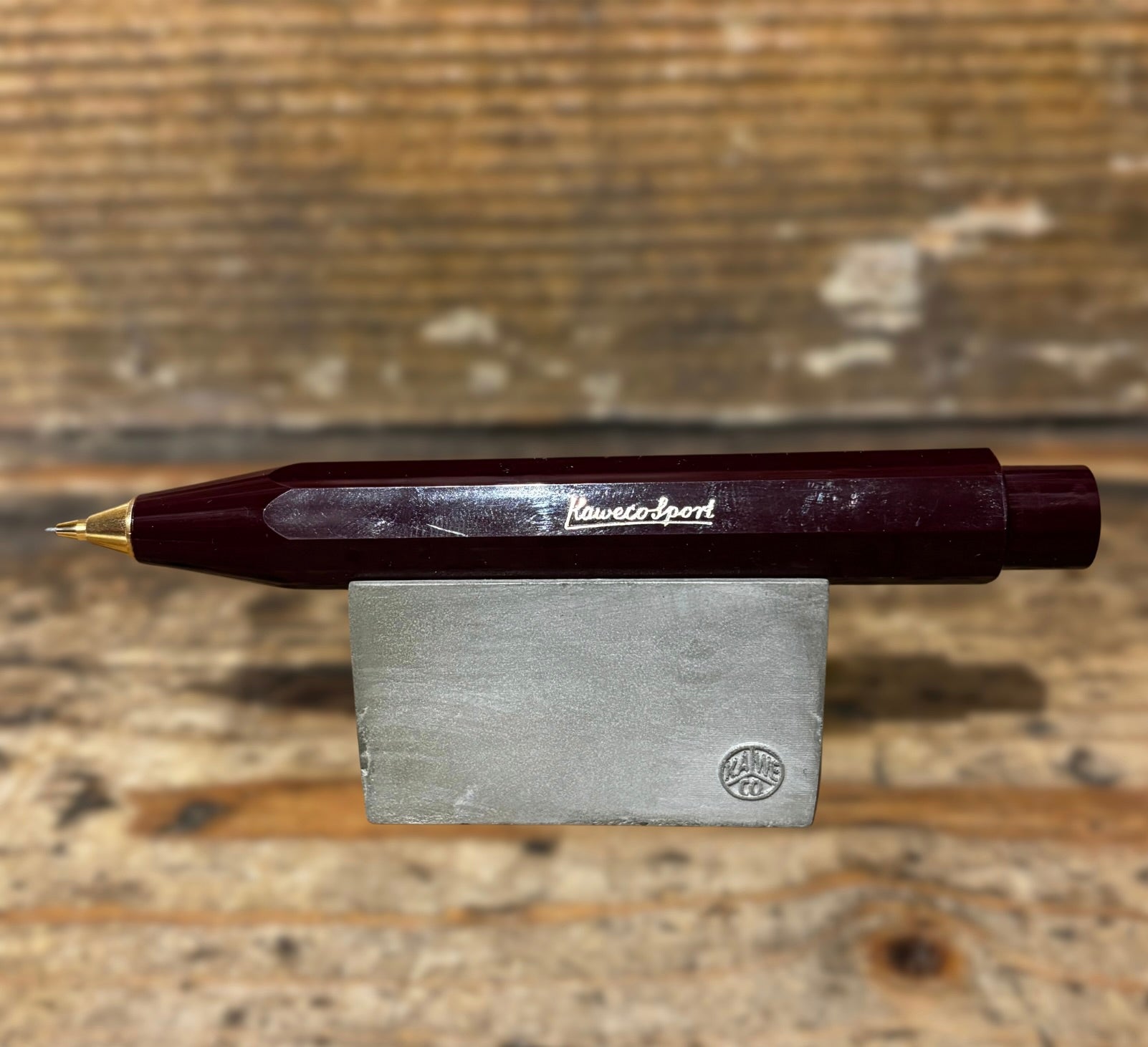 Burgundy Kaweco Ballpoint Pen on wooden block and wooden background