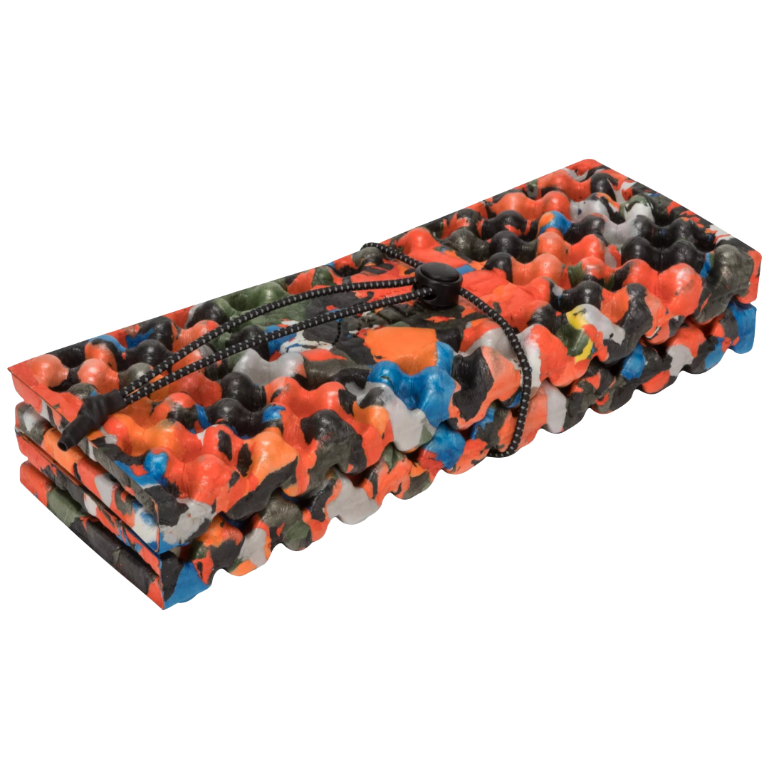 A rolled-up foam mat with a vibrant multicolor camouflage pattern in orange, black, gray, and blue, secured with a black drawstring, shown on a plain white background.