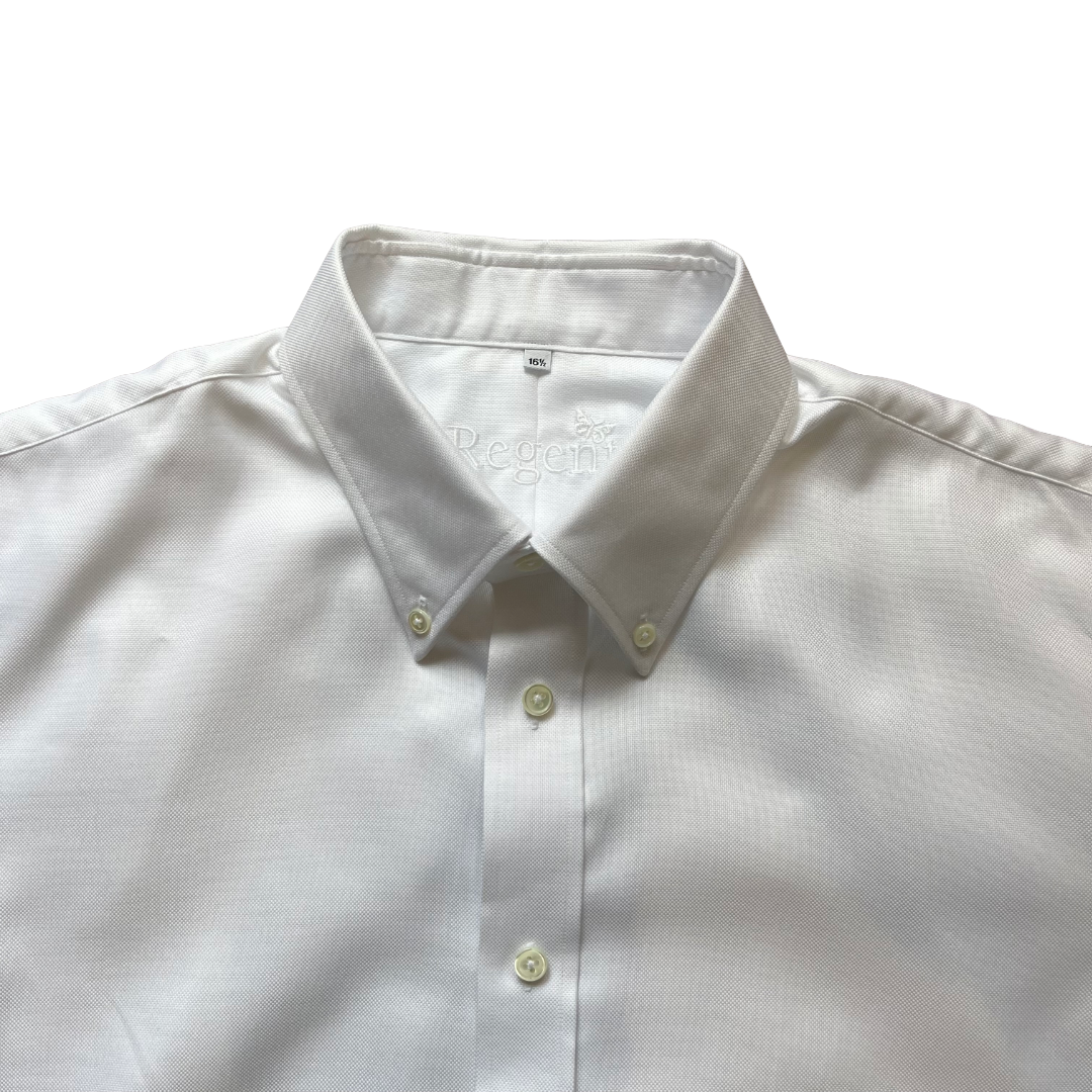 A close-up of a white long-sleeve button-down shirt with a classic collar and light-colored buttons, laid flat against a white background.