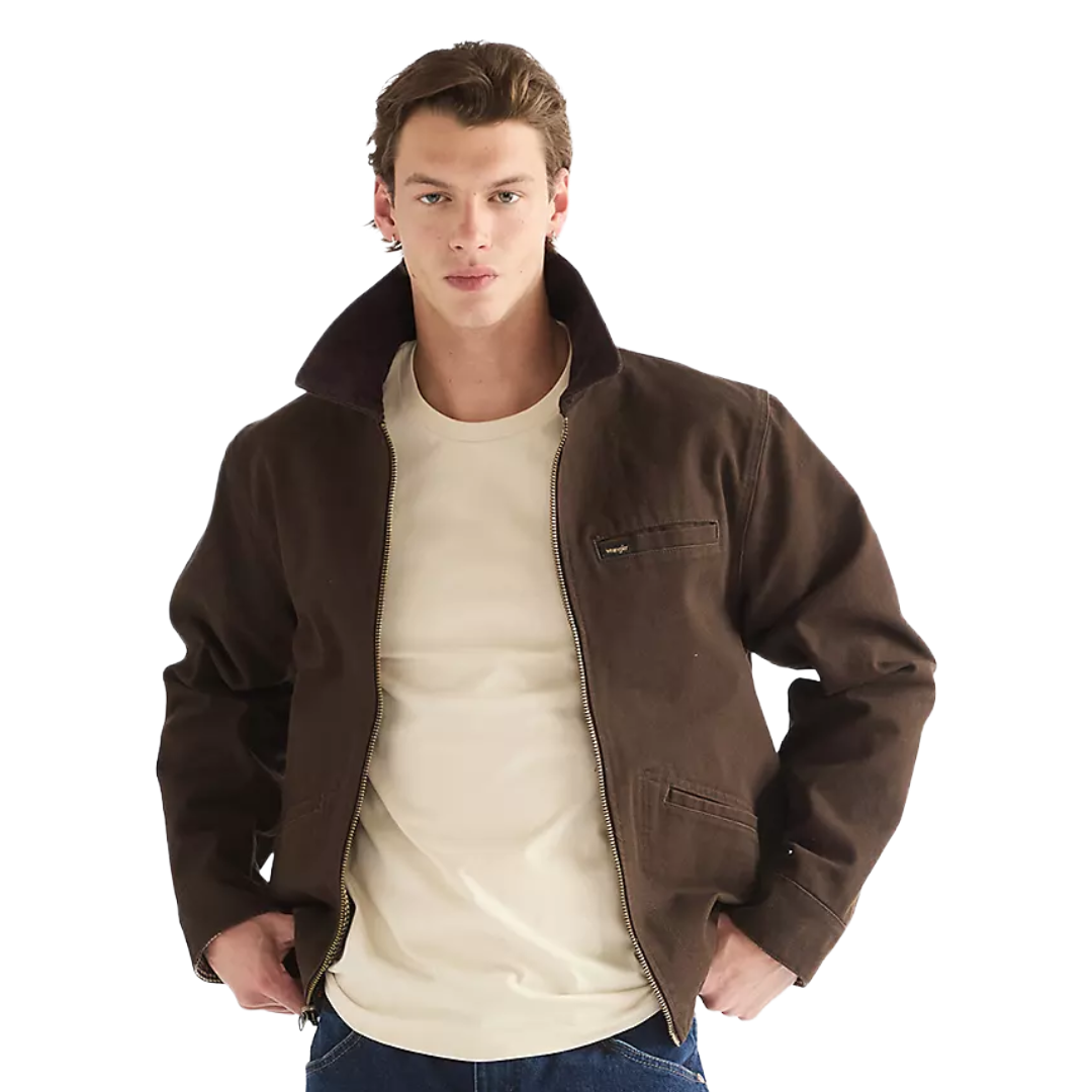 A man wearing a dark brown jacket with a beige crewneck t-shirt and blue jeans, photographed against a solid white background.