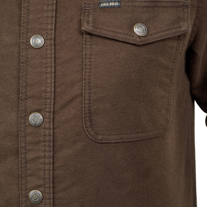 Close-up of a brown button-up shirt with a chest pocket, metal snap buttons, and a visible FIKR.BROS. label.