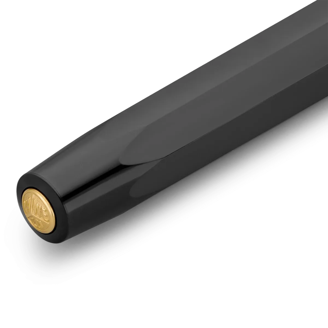 Close-up of a black pen barrel with a gold circular logo accent on the end, photographed on a clean white background.