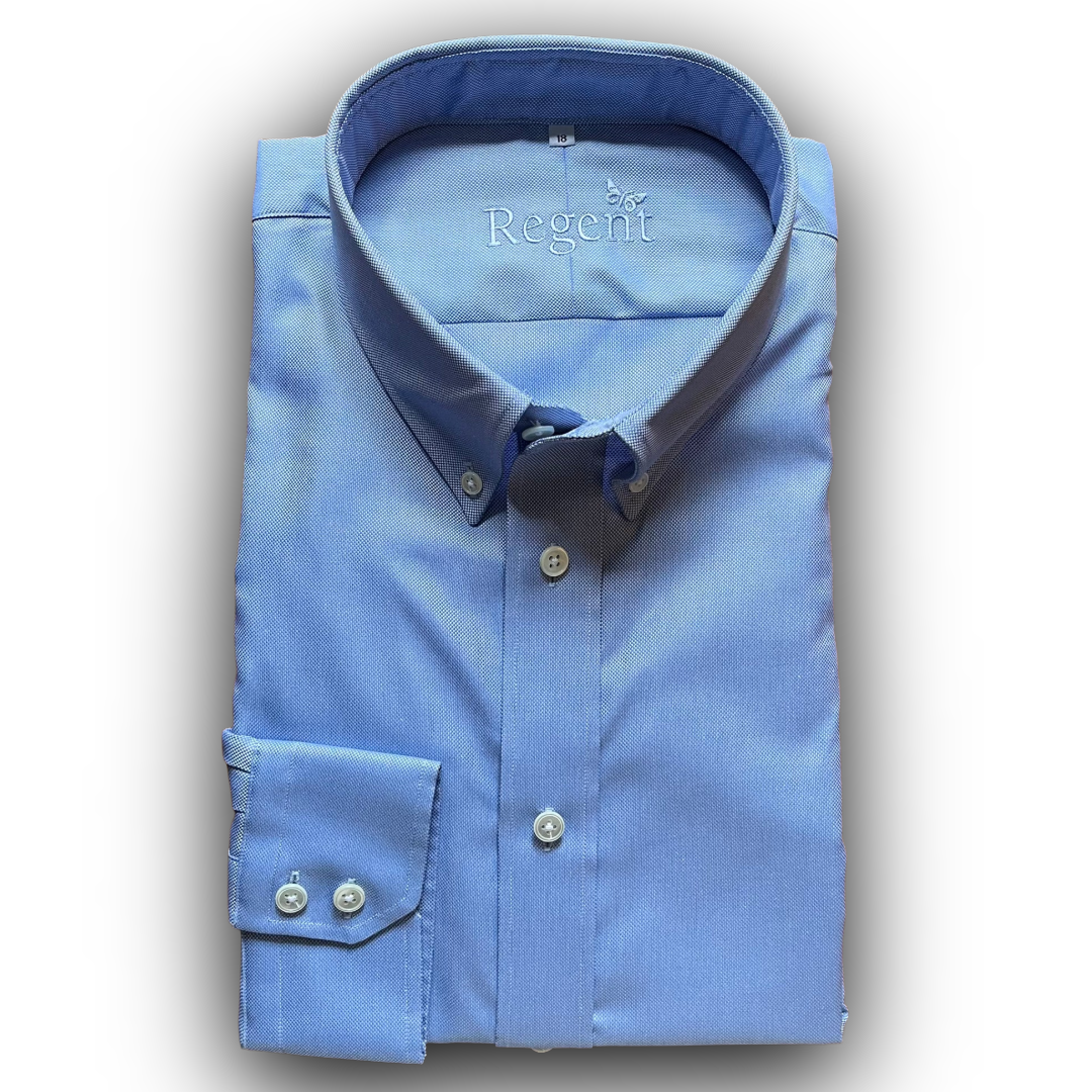 Folded blue oxford shirt with 'Regent' branding on a white background