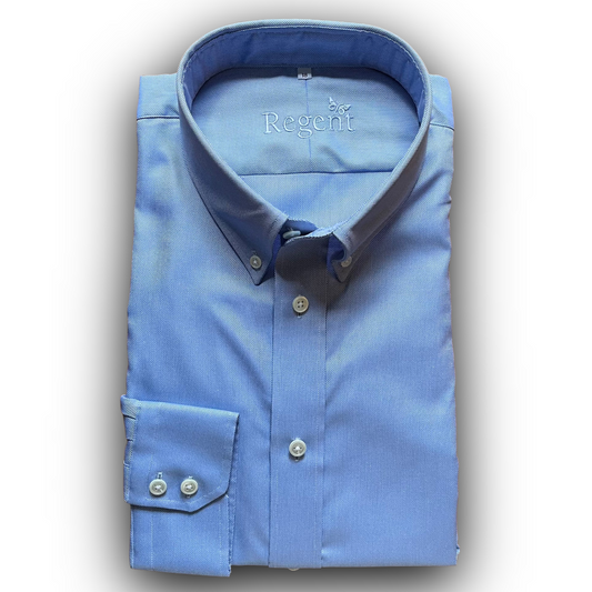 Folded blue oxford shirt with 'Regent' branding on a white background