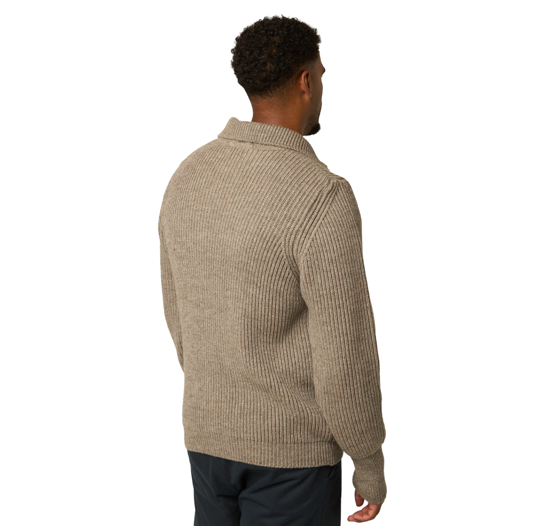 A man viewed from the back wearing a ribbed knit half-zip sweater in a warm taupe-beige color, paired with dark pants, against a plain white background.