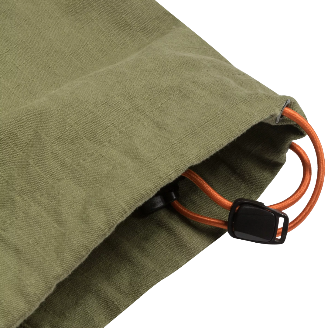 Close-up of an olive green canvas drawstring bag with an orange elastic cord and a black plastic toggle clasp, shown on a white background.