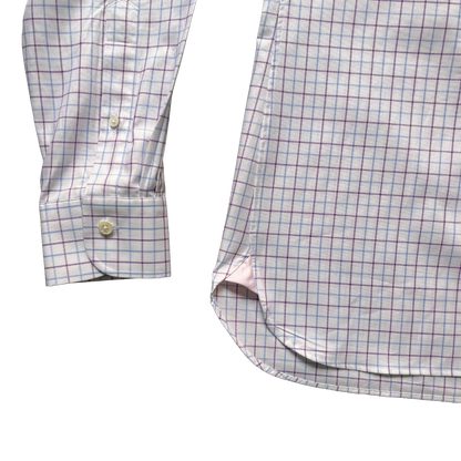 Close-up of a long-sleeve button-up shirt showing the sleeve cuff and main body, featuring a fine windowpane check pattern in light blue and burgundy on a white base.