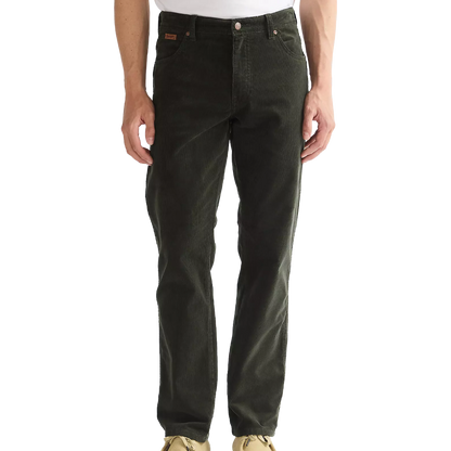 A person wearing dark olive green corduroy pants, shown from the waist down against a plain white background.