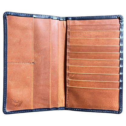 An open leather wallet or card holder showing its interior layout, with a warm tan-brown leather interior, multiple card slots on the right, a vertical divider on the left, and a stitched dark blue outer border.