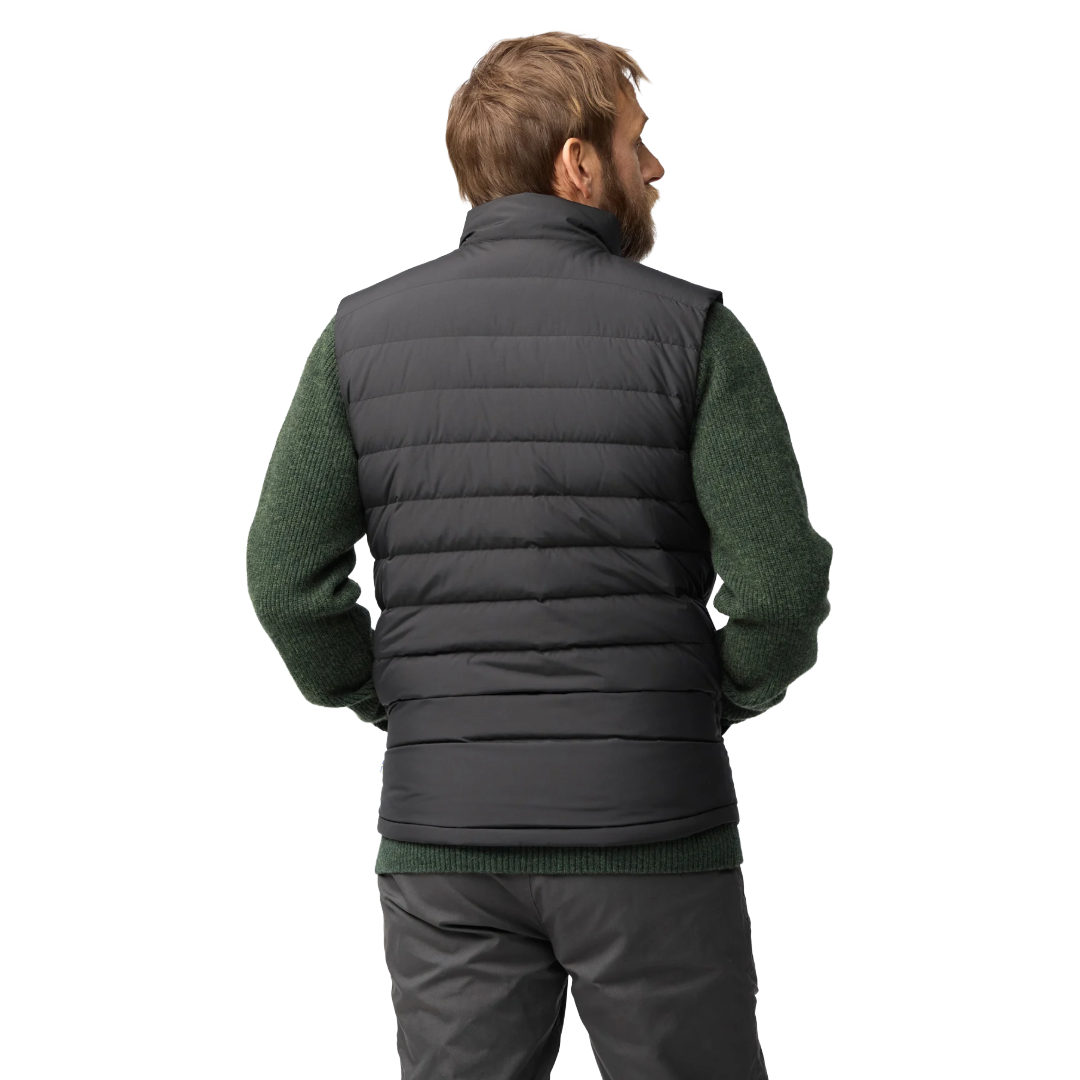 A man shown from the back wearing a dark gray quilted puffer vest over a dark green knit sweater and gray pants, against a plain white background.