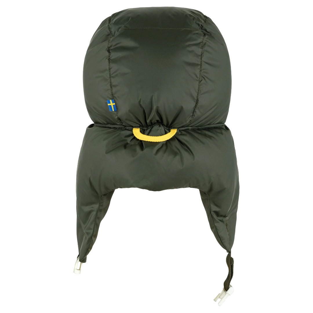 An olive green insulated winter trapper hat with ear flaps, a yellow drawstring loop, and a small Swedish flag patch on the side, shown against a plain white background.