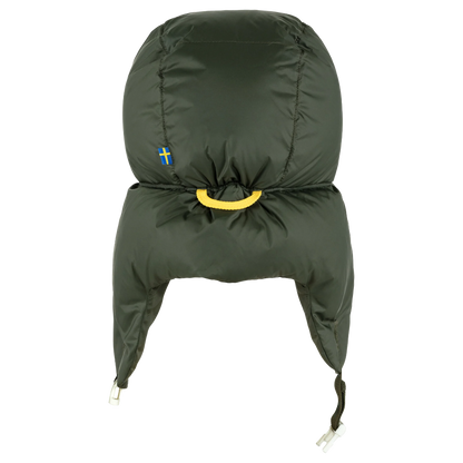 An olive green insulated winter trapper hat with ear flaps, a yellow drawstring loop, and a small Swedish flag patch on the side, shown against a plain white background.