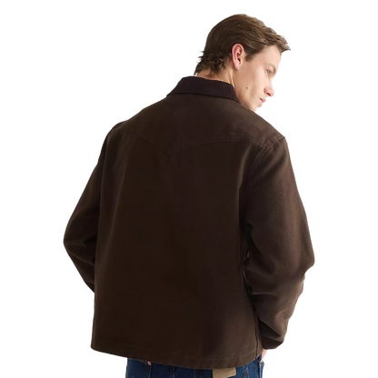 A man wearing a dark brown canvas utility jacket, shown from a three-quarters back view against a solid white background.