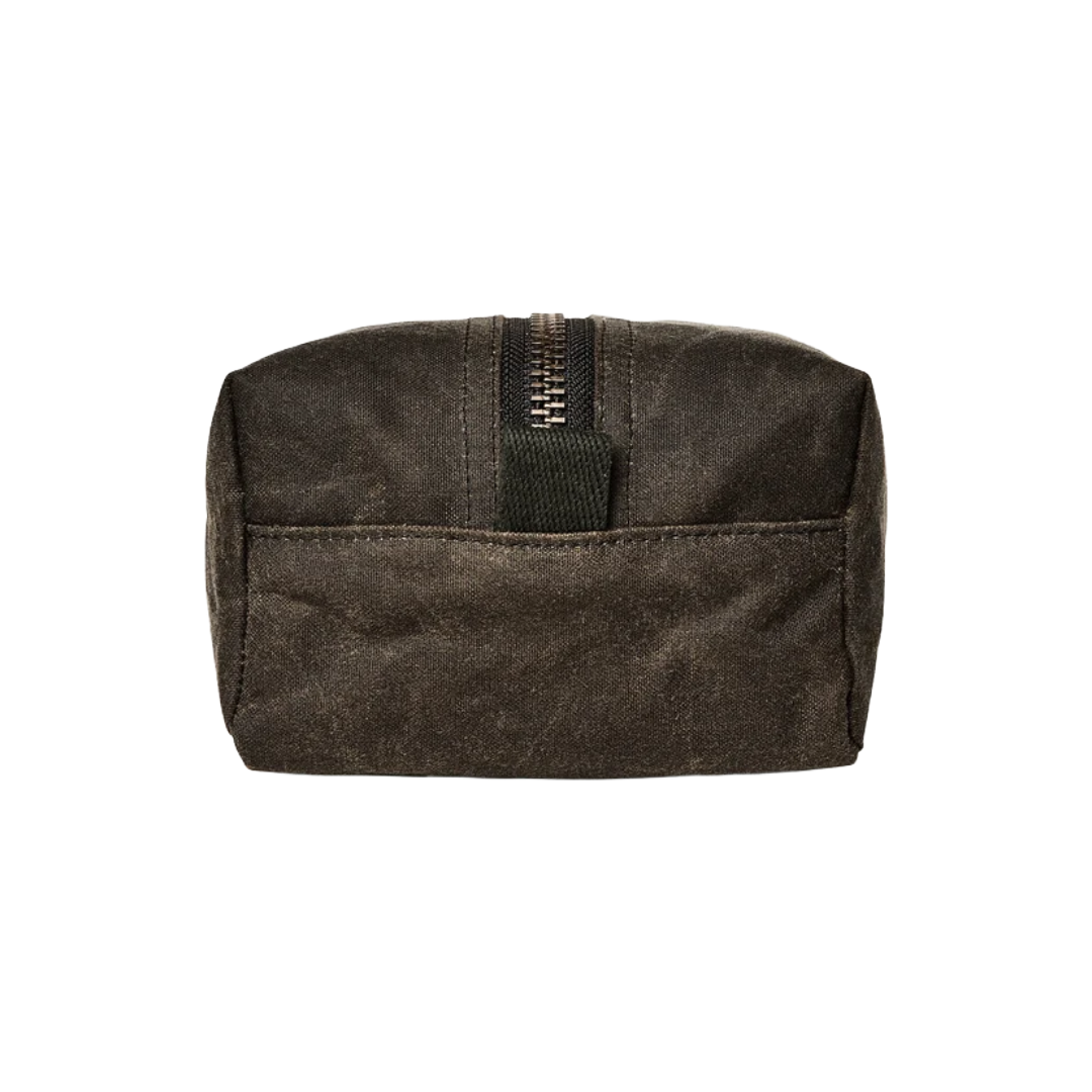A dark brown waxed canvas zippered pouch with a front pocket and a black webbing pull tab, shown against a plain white background.