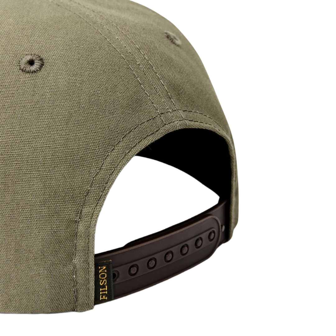 Close-up of the back of an olive green baseball cap with a dark brown adjustable strap and a small gold FILSON logo tag.
