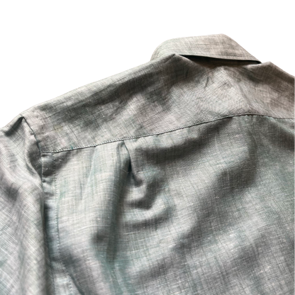 Close-up of a textured gray linen shirt showing the collar, shoulder seam, and fabric weave against a white background.