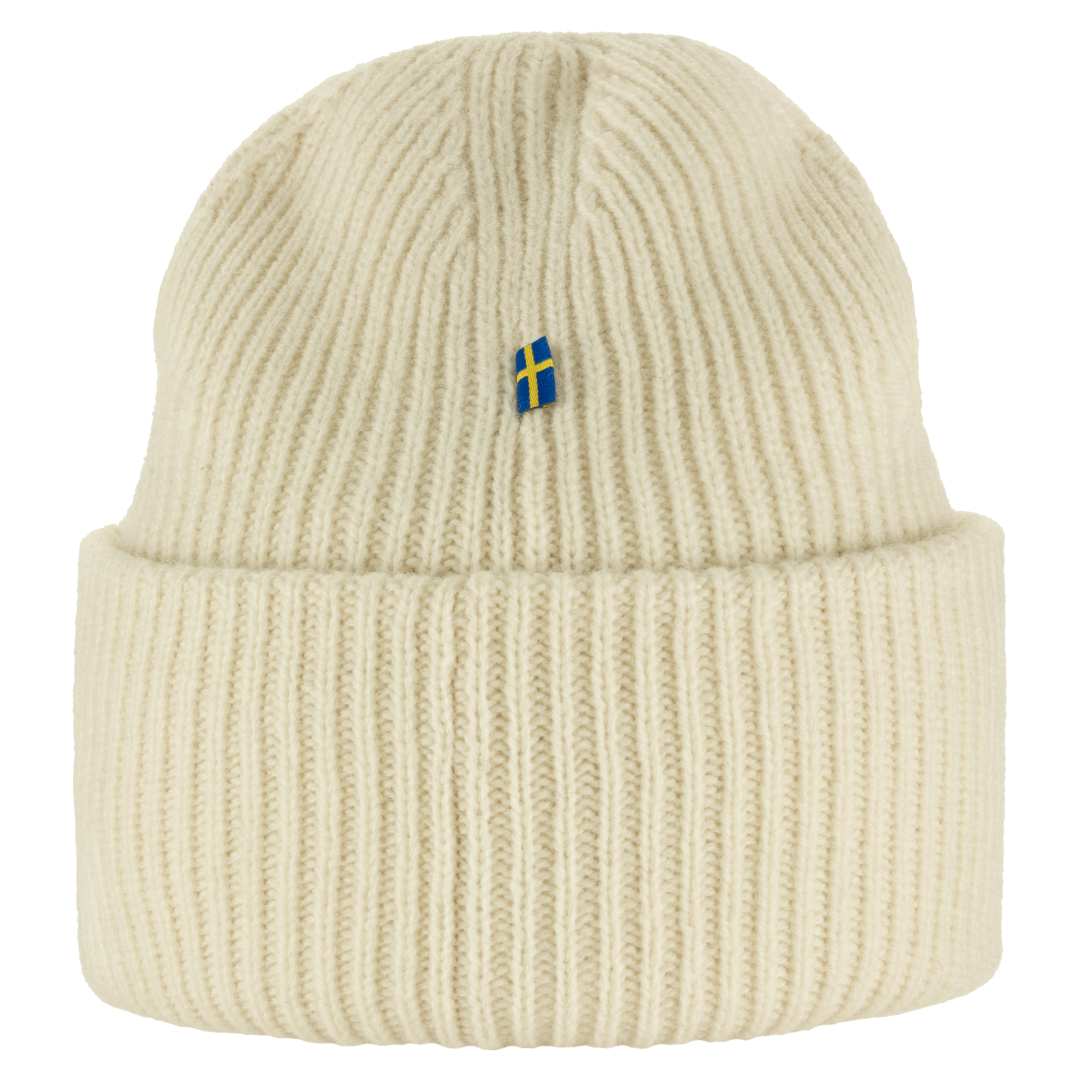 A cream-colored ribbed knit beanie hat featuring a small Swedish flag embroidered on the front, set against a plain white background.