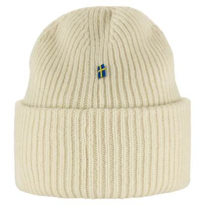 A cream-colored ribbed knit beanie hat featuring a small Swedish flag embroidered on the front, set against a plain white background.