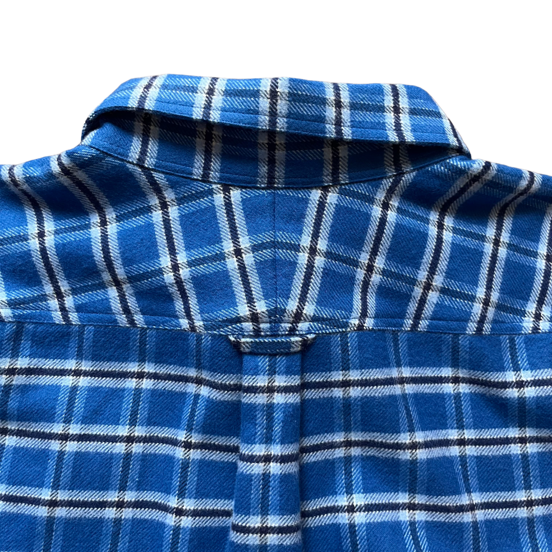 Close-up of a blue plaid flannel shirt showing the collar, back yoke, and button placket 
