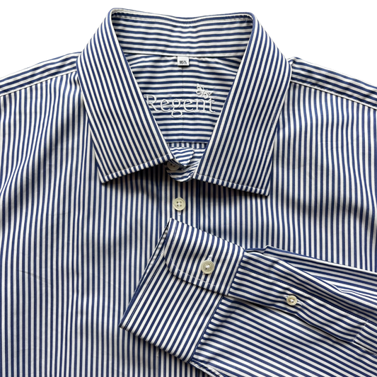 A close-up of a Regatta men's dress shirt featuring a navy and white vertical stripe pattern, with a folded cuff showing the button-down design.