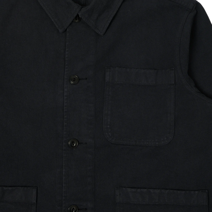 Close-up of a dark charcoal gray or black work shirt jacket, showing the collar, front button closure, chest pocket, and lower patch pockets.