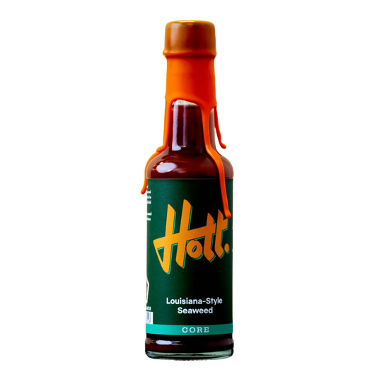 A bottle of Hott. Louisiana-Style Seaweed sauce on a solid white background, featuring a dark green label with a stylized yellow-orange Hott.