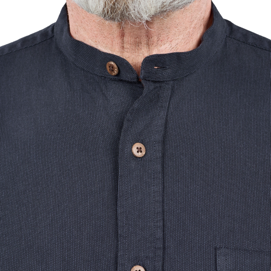 Close-up of a person wearing a dark navy textured shirt with a mandarin collar and brown buttons.
