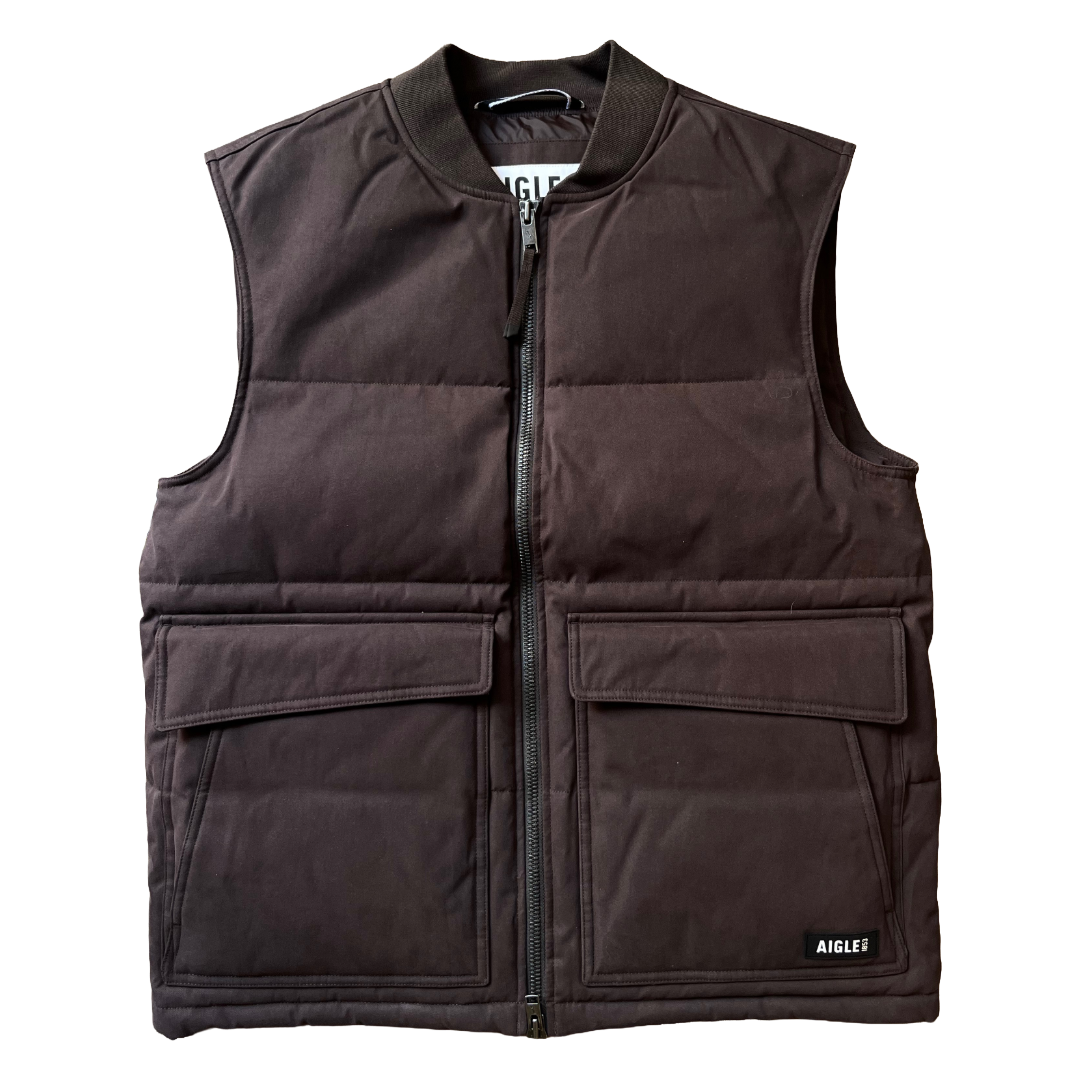A dark brown sleeveless puffer vest with a front zipper, ribbed collar, and two large front flap pockets, shown flat against a white background.