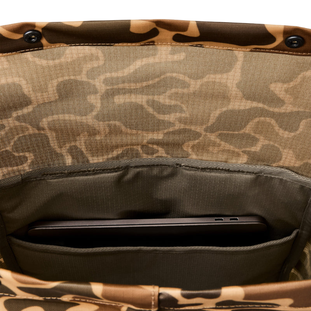 Close-up of the interior of a camouflage-patterned bag showing a phone pocket holding a dark gray smartphone.