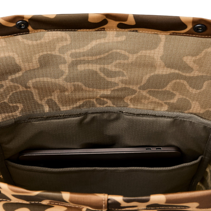 Close-up of the interior of a camouflage-patterned bag showing a phone pocket holding a dark gray smartphone.