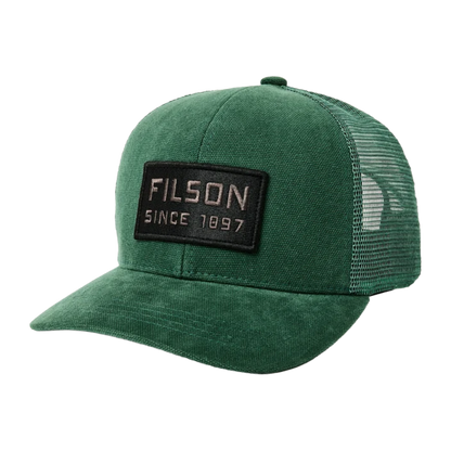 A green trucker hat with a black rectangular patch on the front that reads 'FILSON SINCE 1897' in white text, shown on a plain white background.
