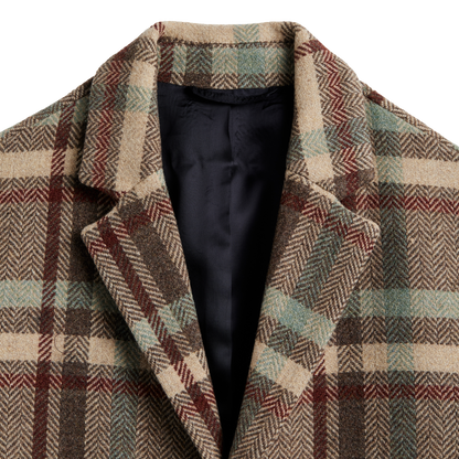 Close-up of a plaid wool coat with a black satin inner lining, featuring a beige, brown, and muted green herringbone pattern.