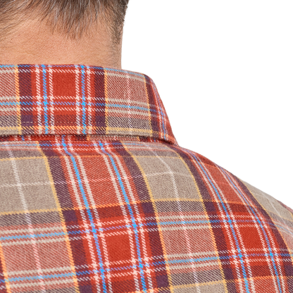 Close-up of a man wearing a collared plaid flannel shirt in rust red, beige, navy, and light blue, with his neck and upper back visible against a plain white background.