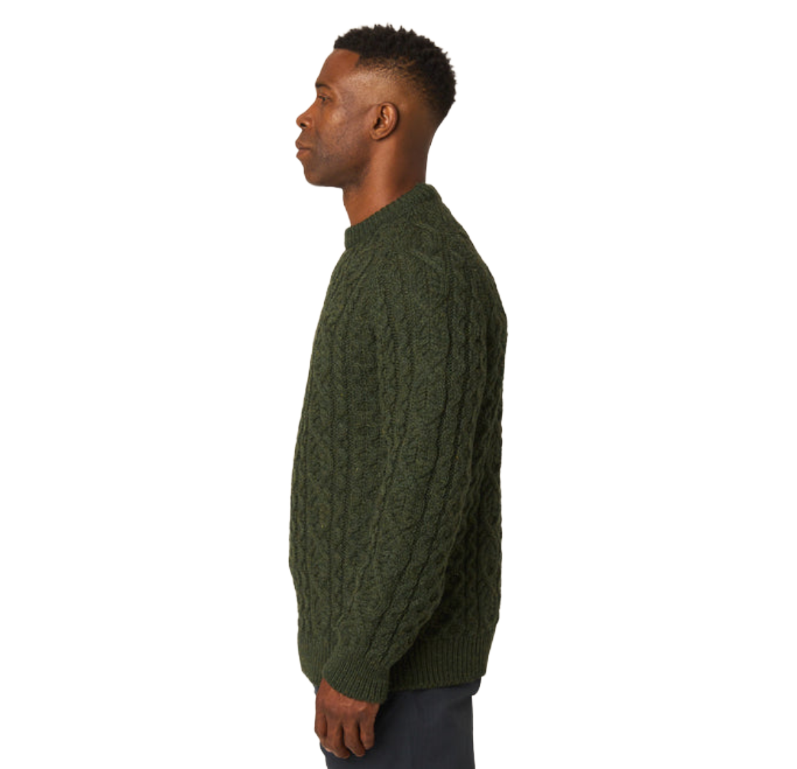 A man shown in profile wearing a dark olive green cable-knit sweater against a plain white background.