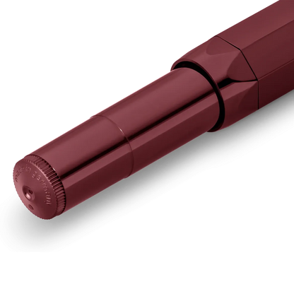 A close-up of a metallic burgundy pen tip and body section on a clean white background.