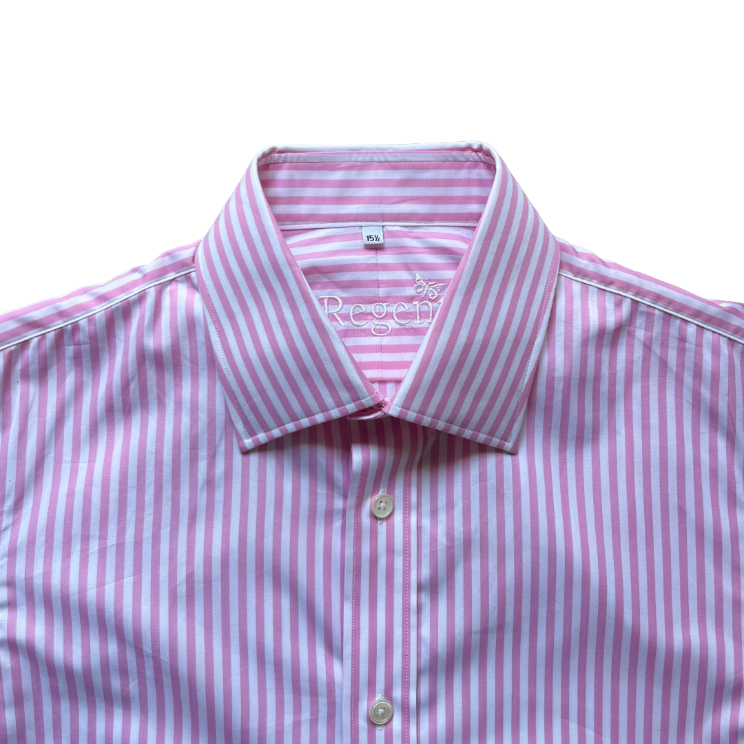 A close-up of a pink and white striped dress shirt with a pointed collar and light-colored buttons, photographed against a plain white background.