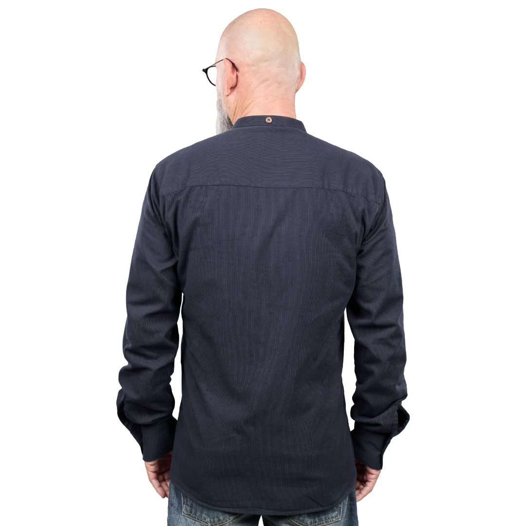 A man viewed from the back wearing a dark navy long-sleeve button-up shirt with a subtle vertical textured stripe pattern, paired with blue jeans.
