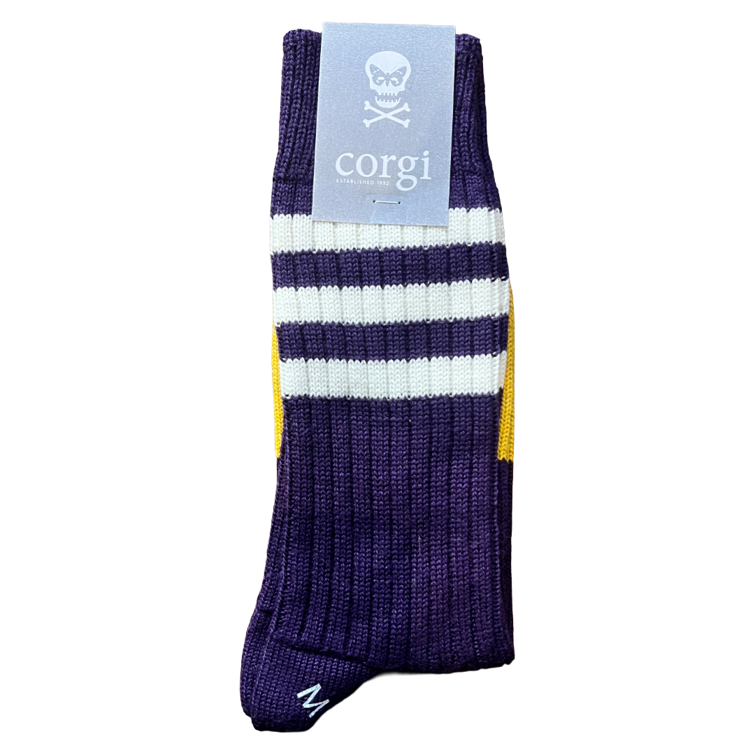 A single purple ribbed knit sock with white and yellow stripes, featuring a light blue paper tag with a skull and crossbones logo and the brand name 'corgi'.