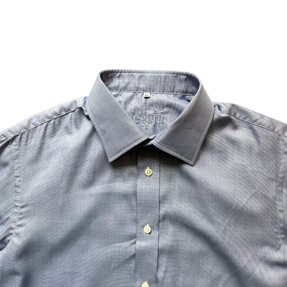 A close-up of a light gray micro-patterned dress shirt with a pointed collar and light-colored buttons, laid flat against a white background.