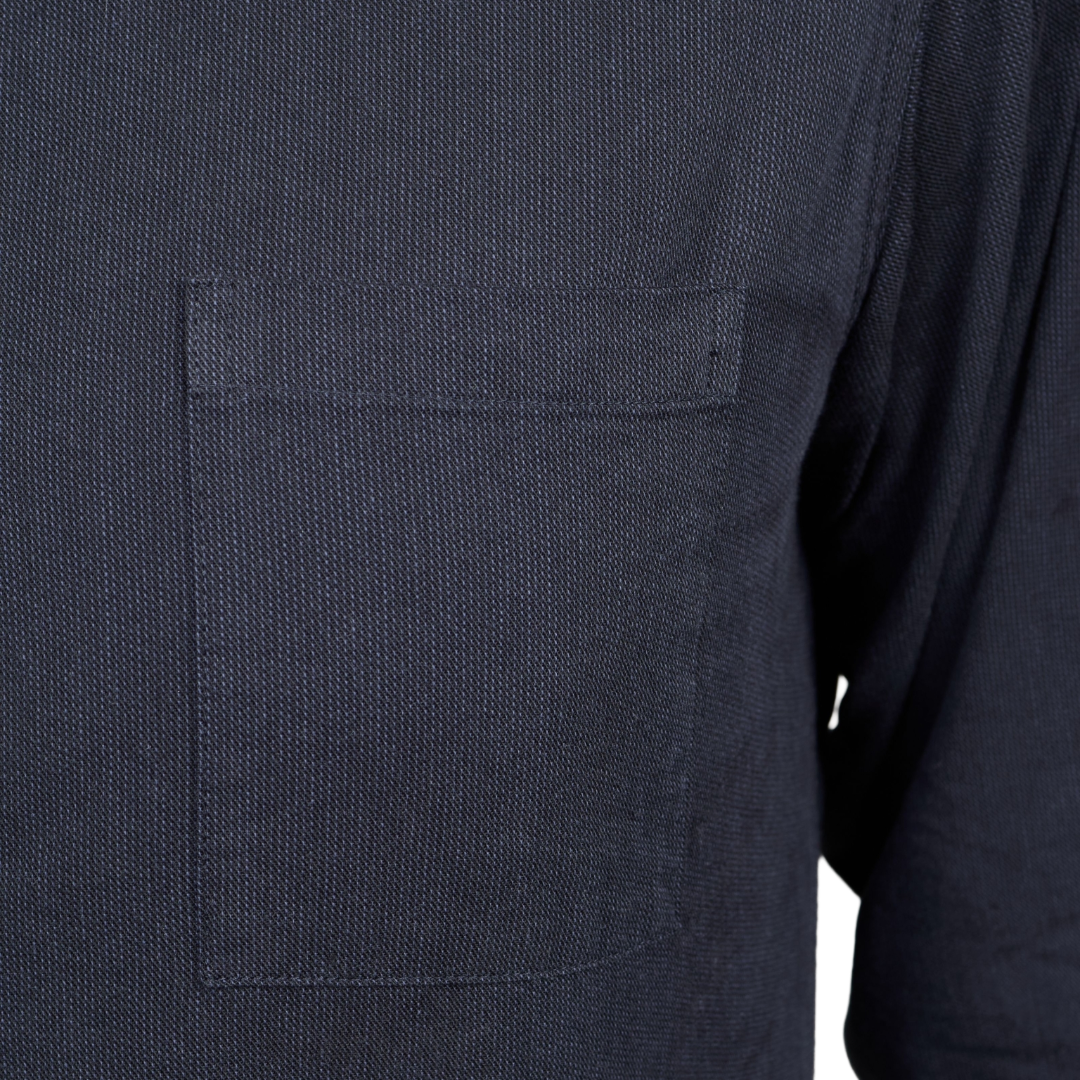 Close-up of a dark navy blue textured fabric garment featuring a single rectangular chest pocket.
