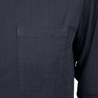 Close-up of a dark navy blue textured fabric garment featuring a single rectangular chest pocket.